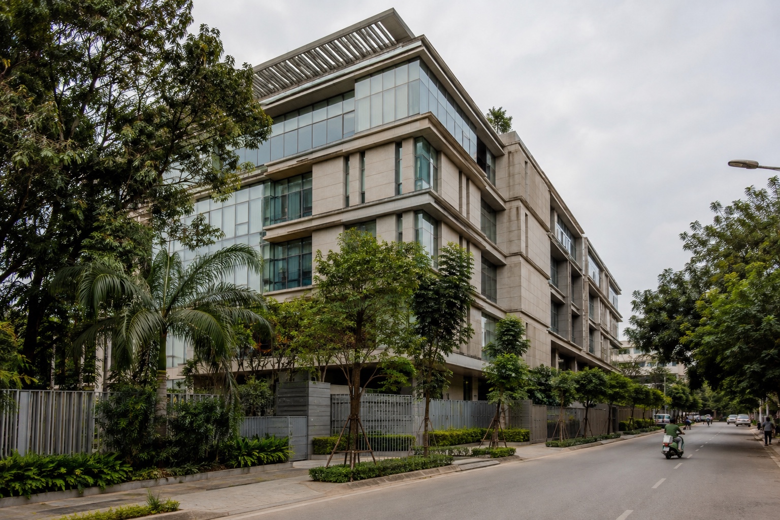 Contemporary Indian office building with warm stone, glass and tropical planting