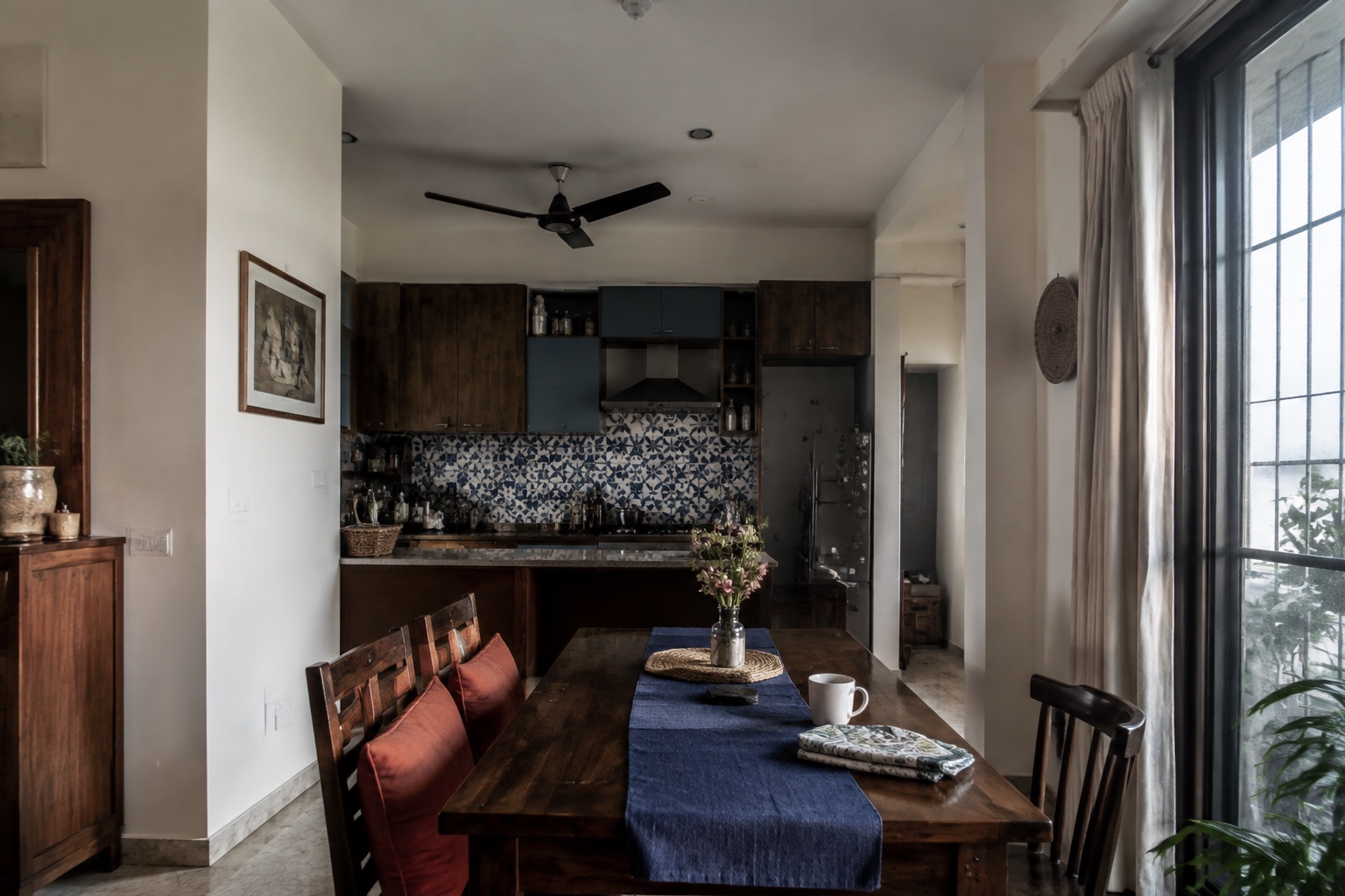 Lived-in Indian apartment with walnut cabinetry, indigo textiles and soft window light