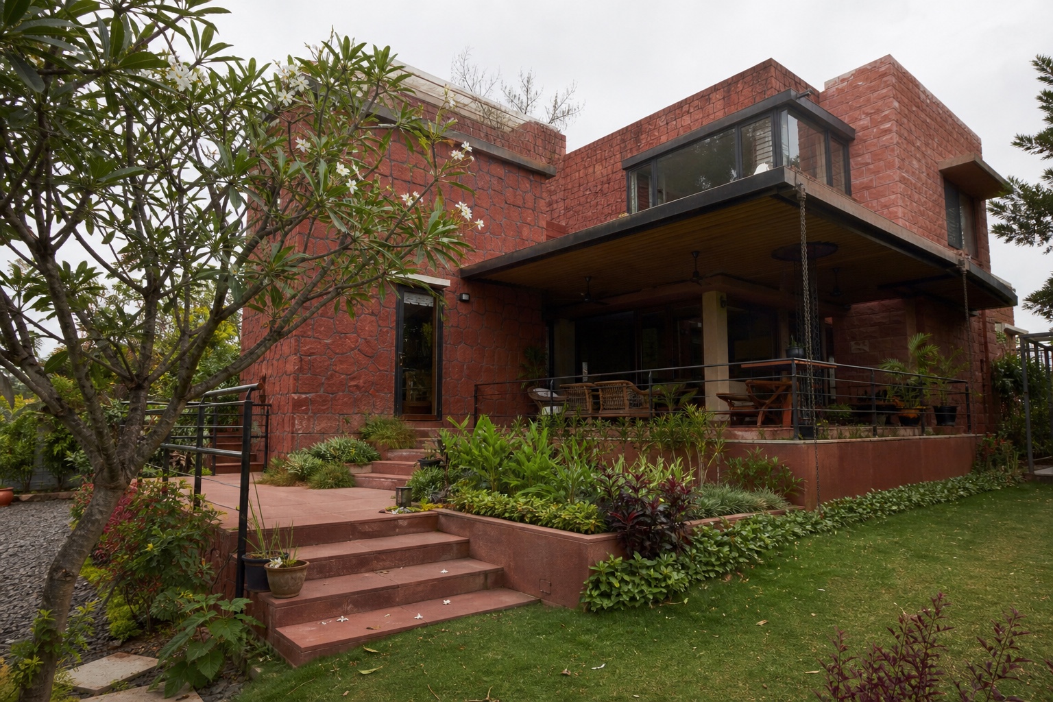 Contemporary Indian family home with laterite stone and a planted garden